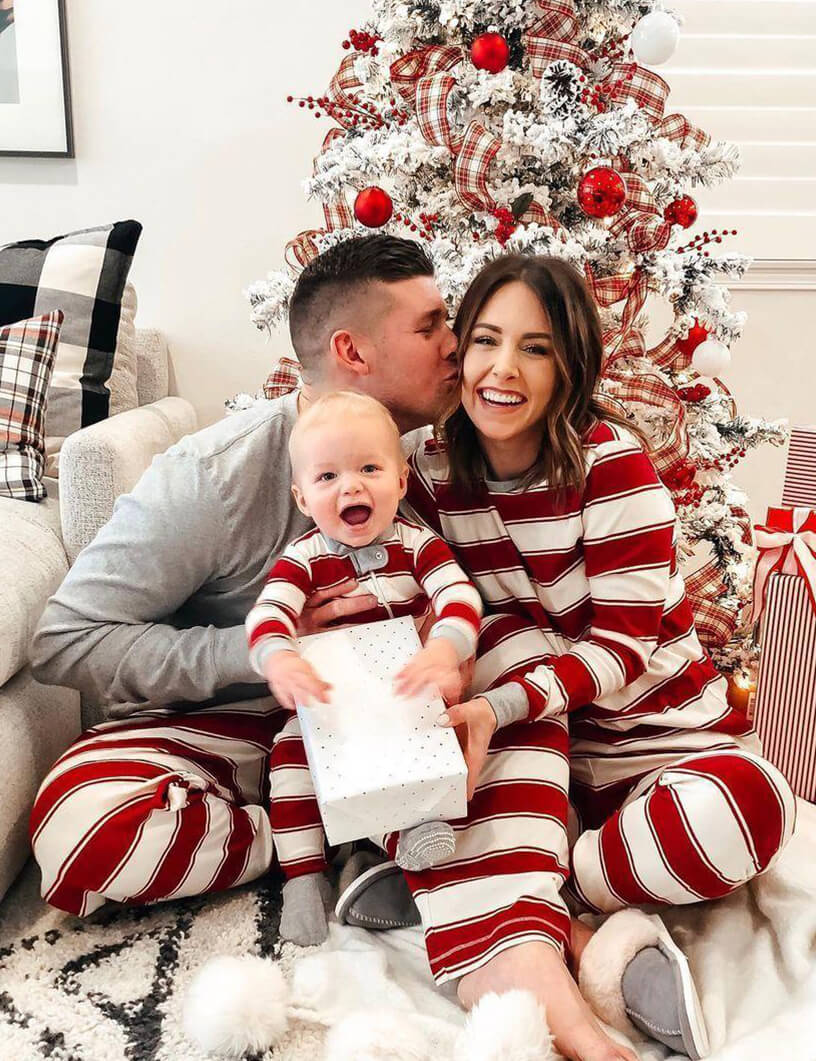 Family wearing matching red and white striped Christmas pajamas with gray trim - view 6
