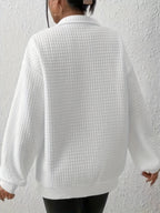 Woman wearing an oversized waffle knit quarter zip sweater with stand collar and ribbed cuffs - view 15