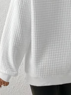 Woman wearing an oversized waffle knit quarter zip sweater with stand collar and ribbed cuffs - view 17