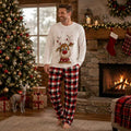Family wearing matching Christmas pajamas with white reindeer print tops and red black plaid pants - view 2