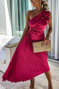 Woman wearing a one-shoulder pleated satin midi dress with a shoulder rosette, waist cutout and asymmetric hem