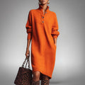 Woman wearing a long sleeve midi sweater dress with a buttoned stand collar and knee-high boots